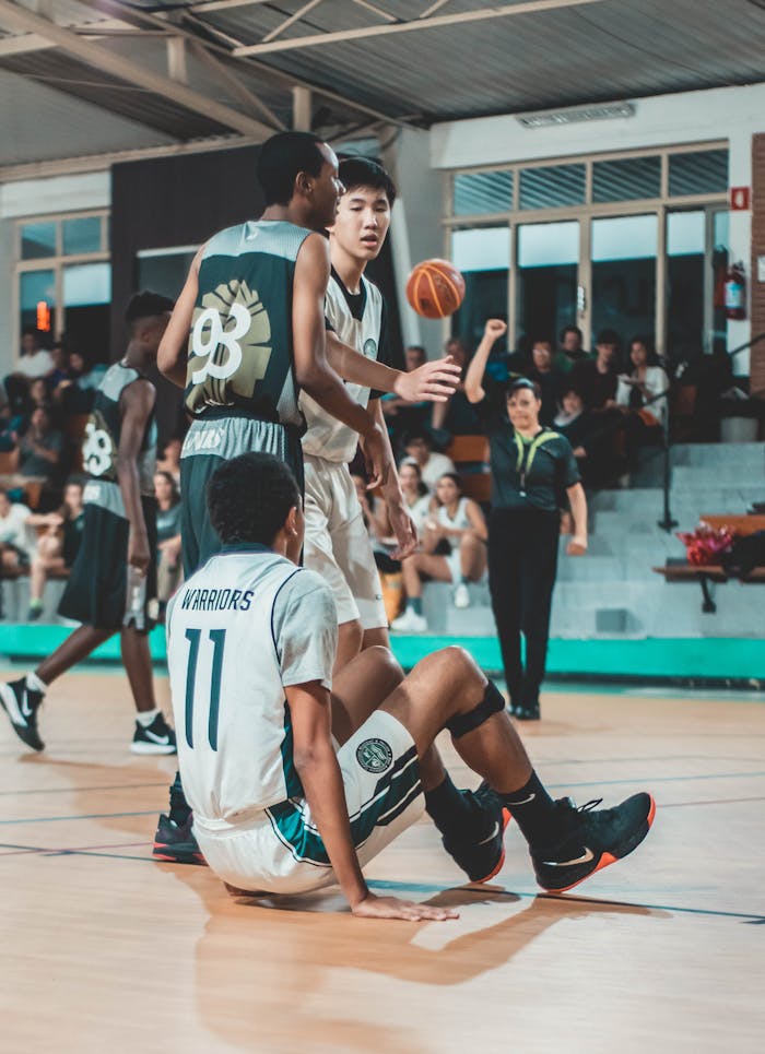 Capture of a competitive indoor basketball game with athletes in action, showcasing teamwork.
